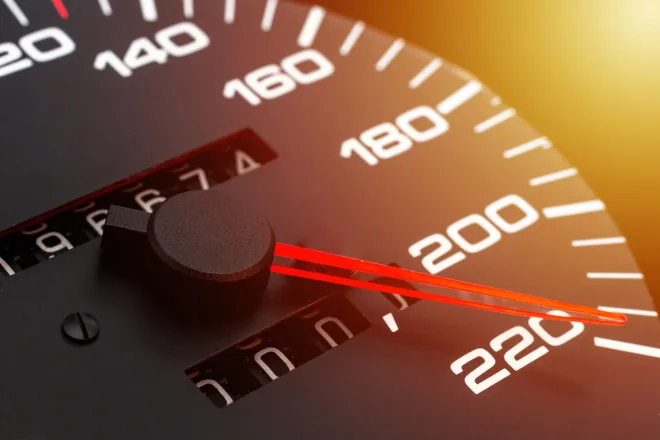 Close-up of a speedometer with the odometer digits part way through rolling over