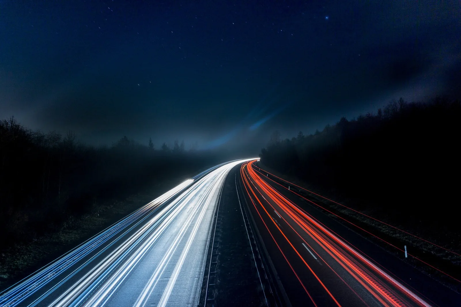 Long exposure of headlight and tail-light trails on a motorway at night