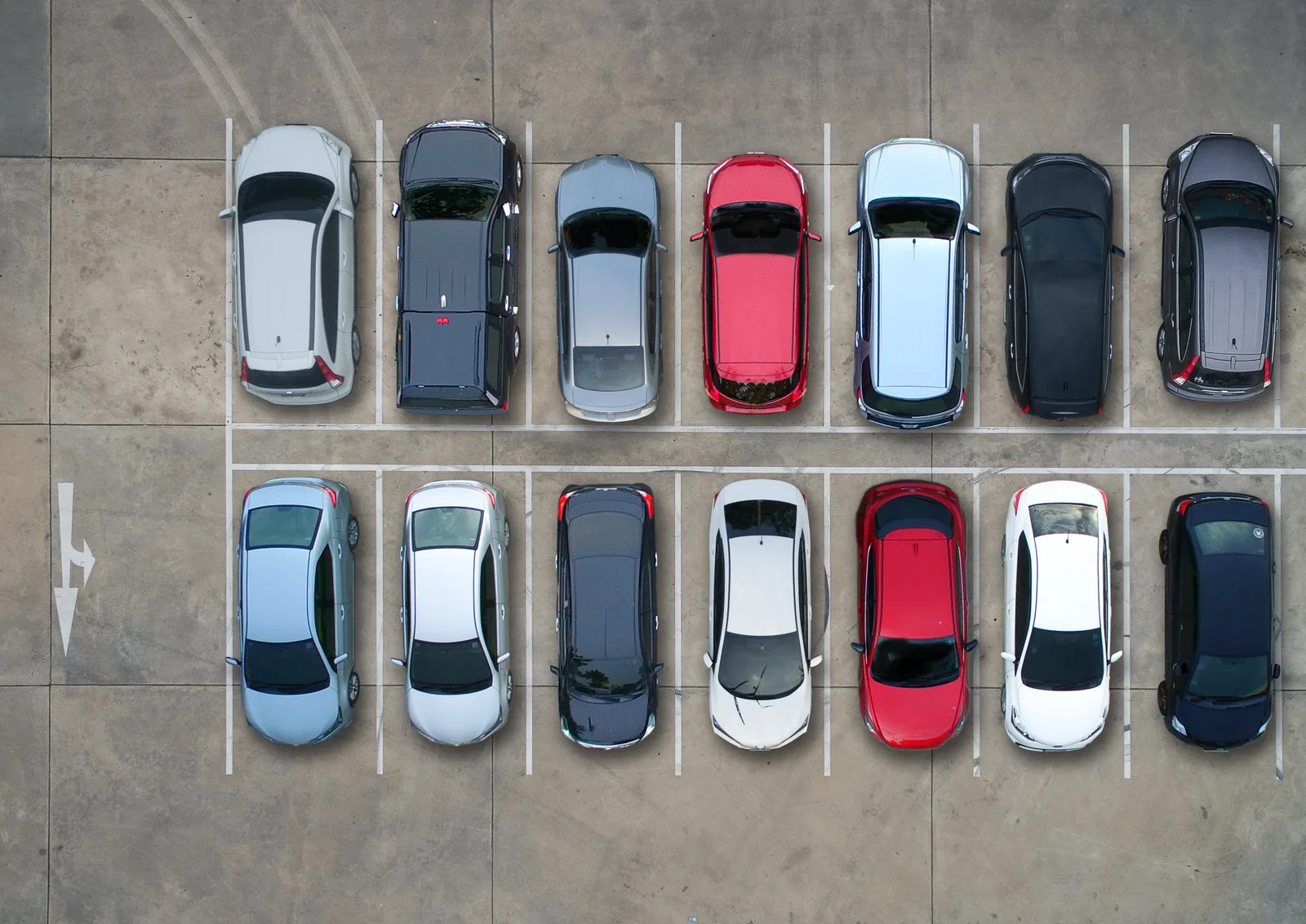Aerial view of two rows of cars parked in marked bays