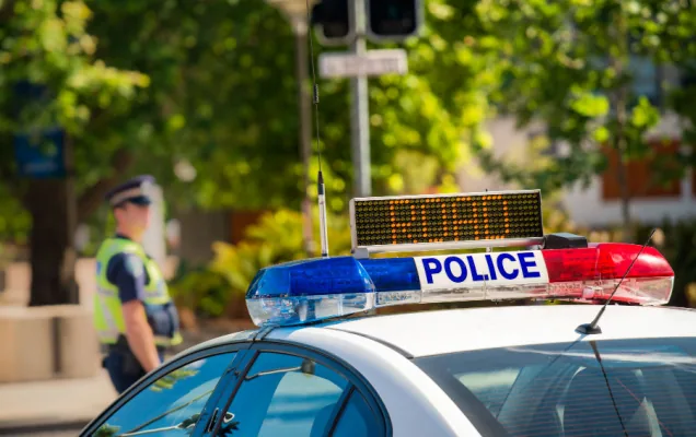 Light bar on an Australian police car with an officer standing in the background