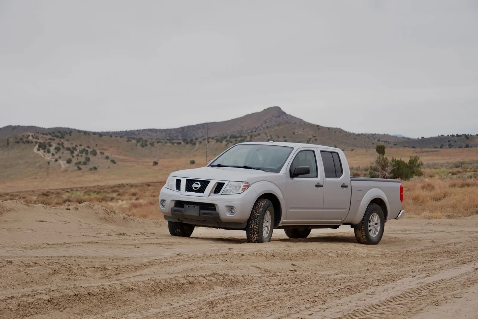 A rugged pick-up ute on a dirt country road, the kind of workhorse that racks up huge distances