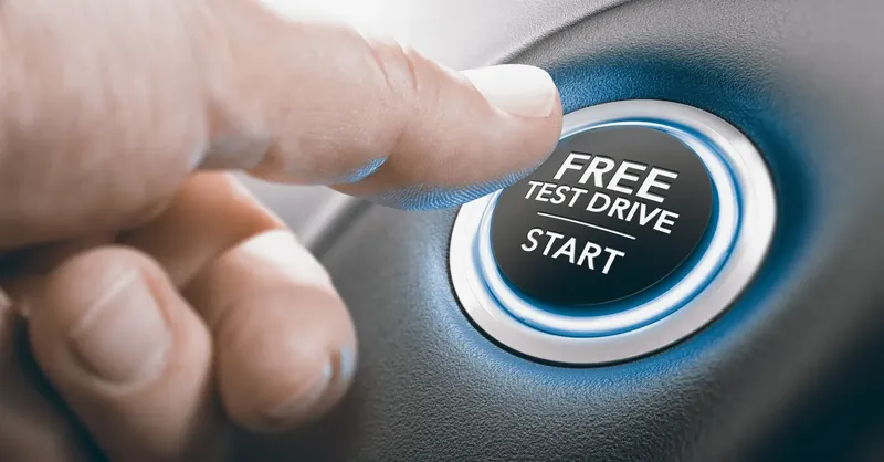 Finger pressing a start button labelled Free Test Drive