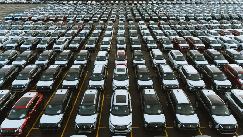 Aerial view of hundreds of used cars lined up in rows at a vehicle storage lot