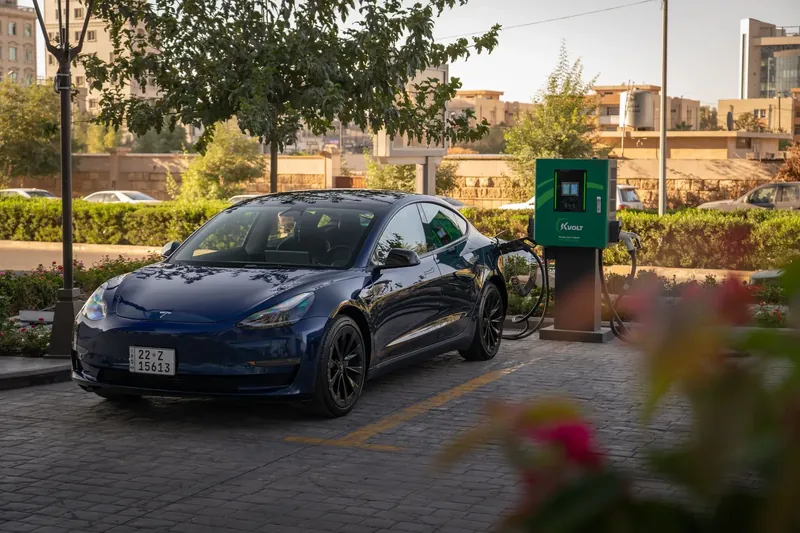 A Tesla Model 3 charging at a public electric-vehicle station