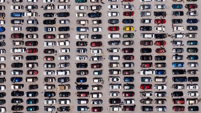 Aerial view of hundreds of cars parked in rows at a storage lot