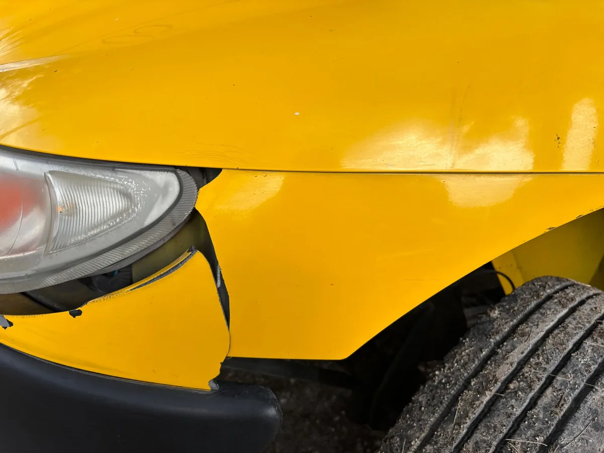 Inspecting a used car's front panel and paintwork for signs of accident repairs